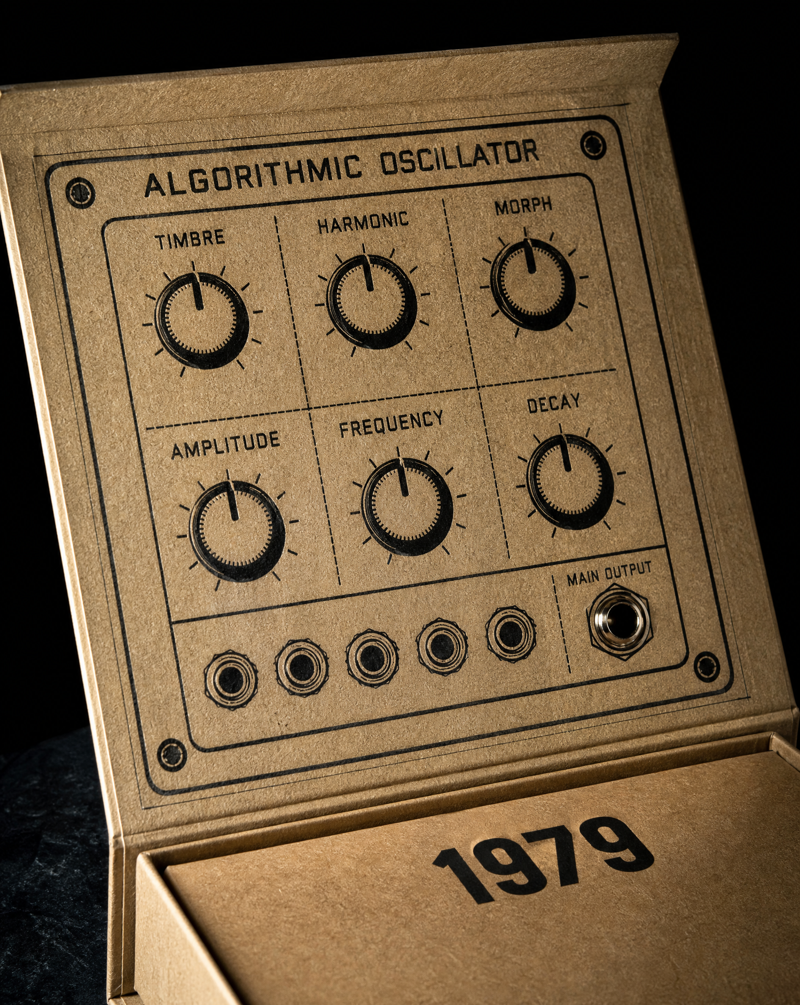 Close detail of the 1979 (Nineteen Seventy Nine) boxes — 6 × 5 × 1.5 in folding chipboard, Natural kraft board, 1-colour letterpress, black, Score and fold.