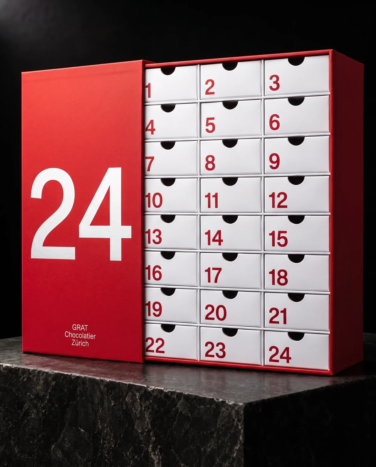 A red advent calendar slipcase with a huge white 24 and GRAT Chocolatier Zürich in small white type, pulled aside to reveal a white cabinet of 24 drawers with bold red flush-left numerals.
