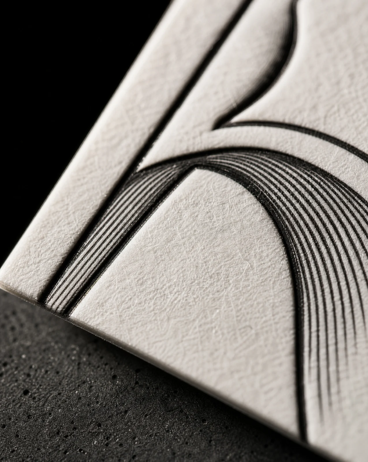 Macro of the Álvarez stone A on cotton stock — engraved line weight thickening into shadow and thinning across the lit face