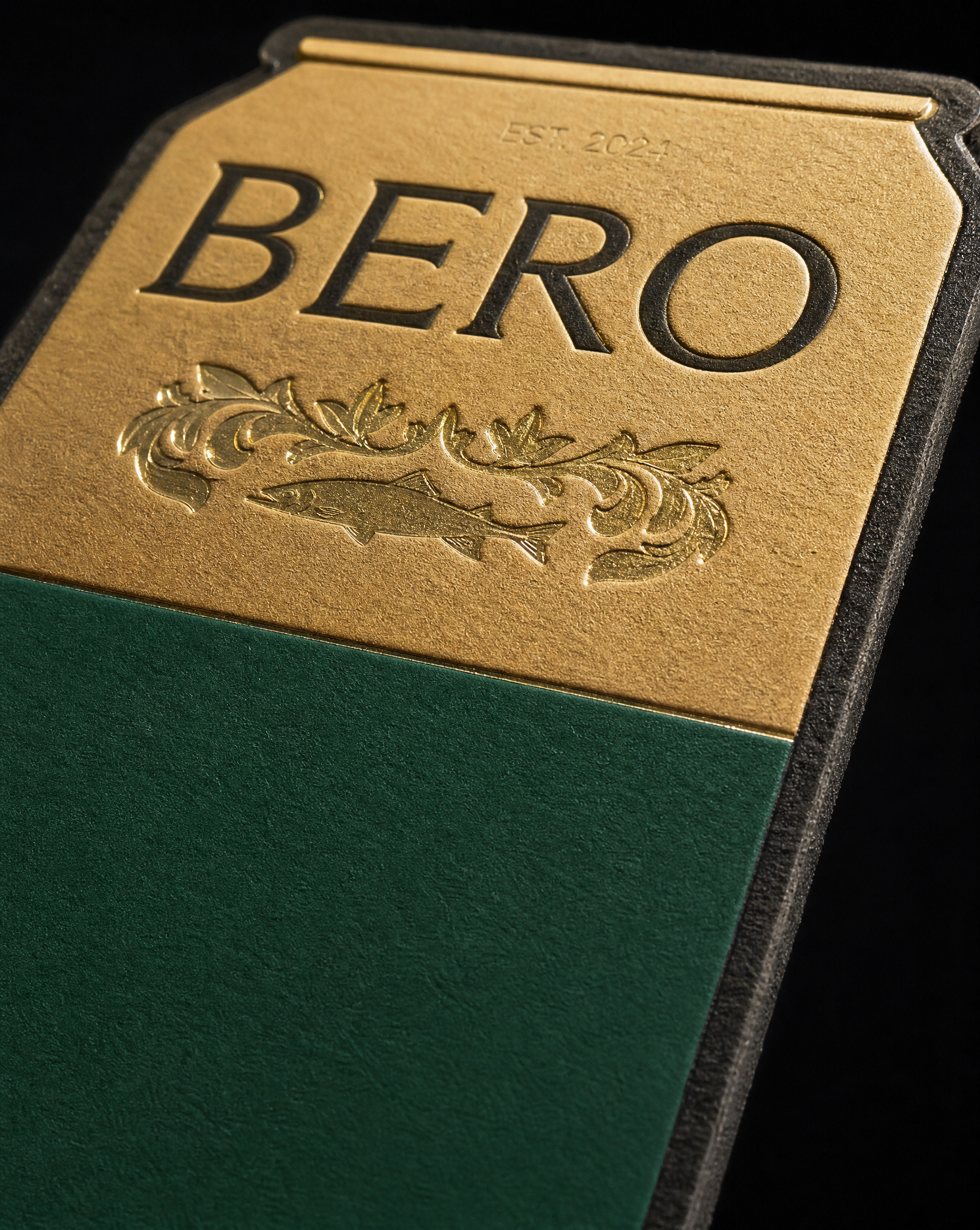 Macro of the KINGSTON GOLDEN PILS panel: matte gold foil, green pigment foil and clear gloss foil on black uncoated paper