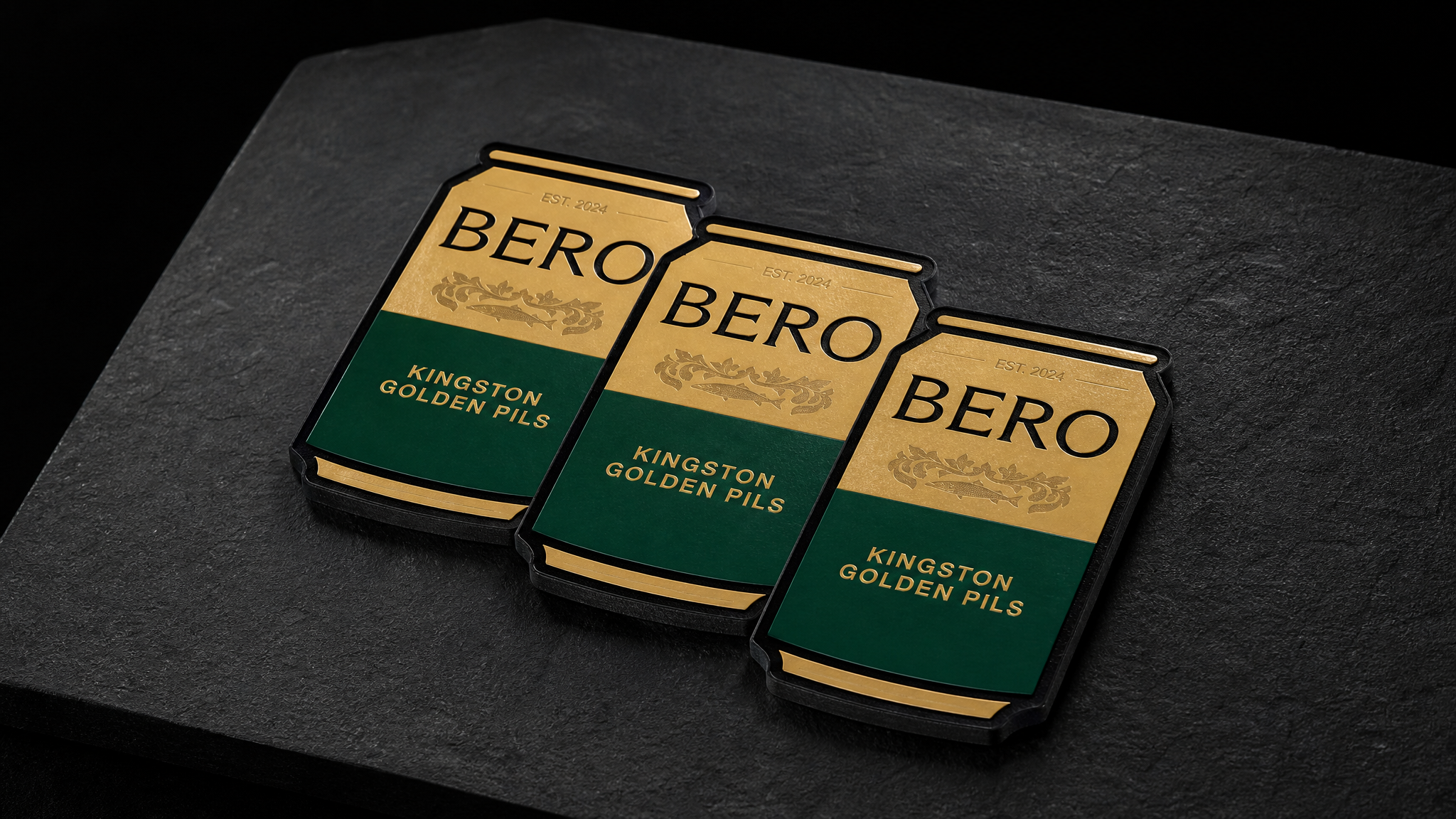 Three can-shaped die-cut BERO business cards stepped to show the crest, the gold-over-green split and the 32pt silhouette