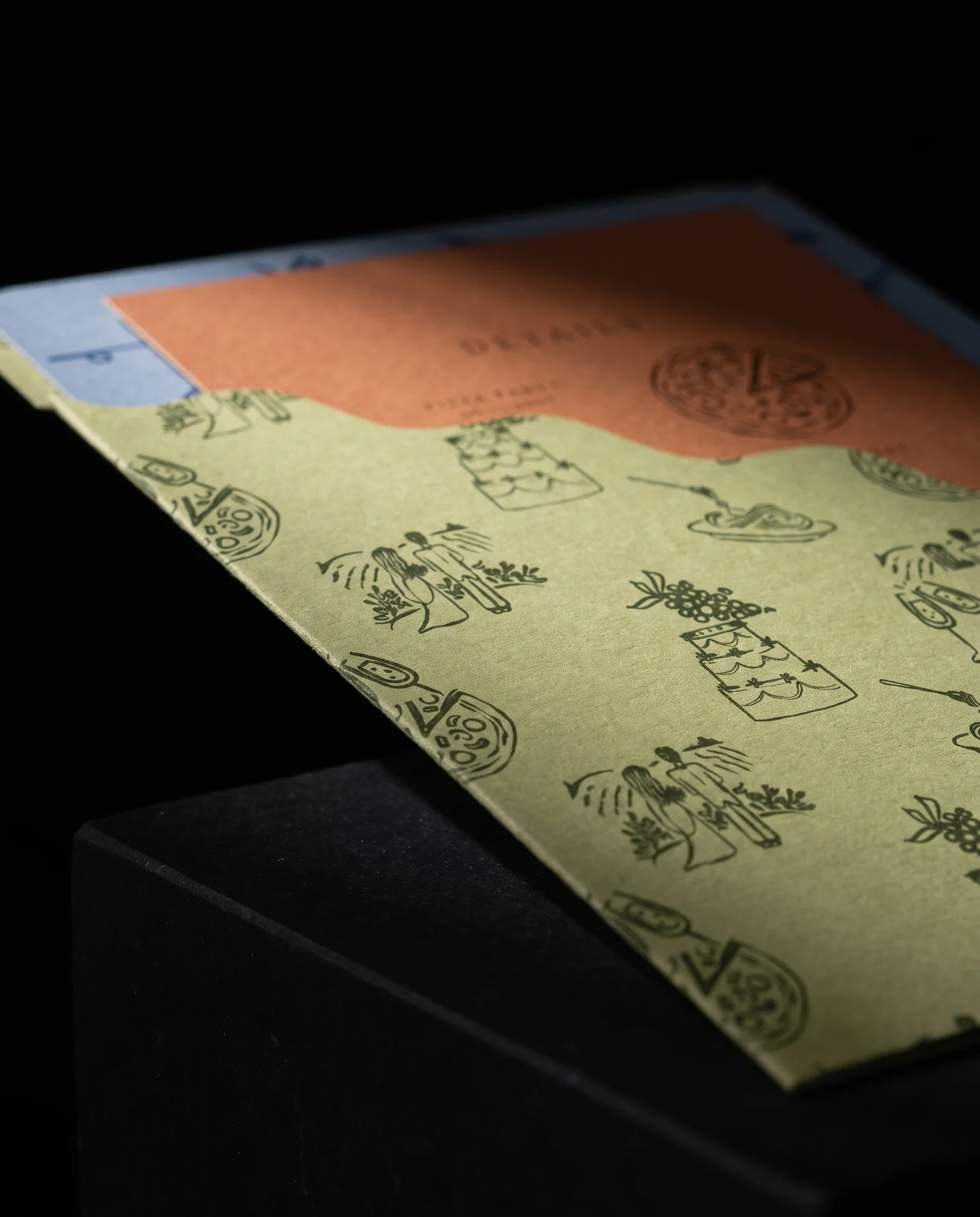Wave-cut sage pocket holding the suite on a black plinth, simulated before press