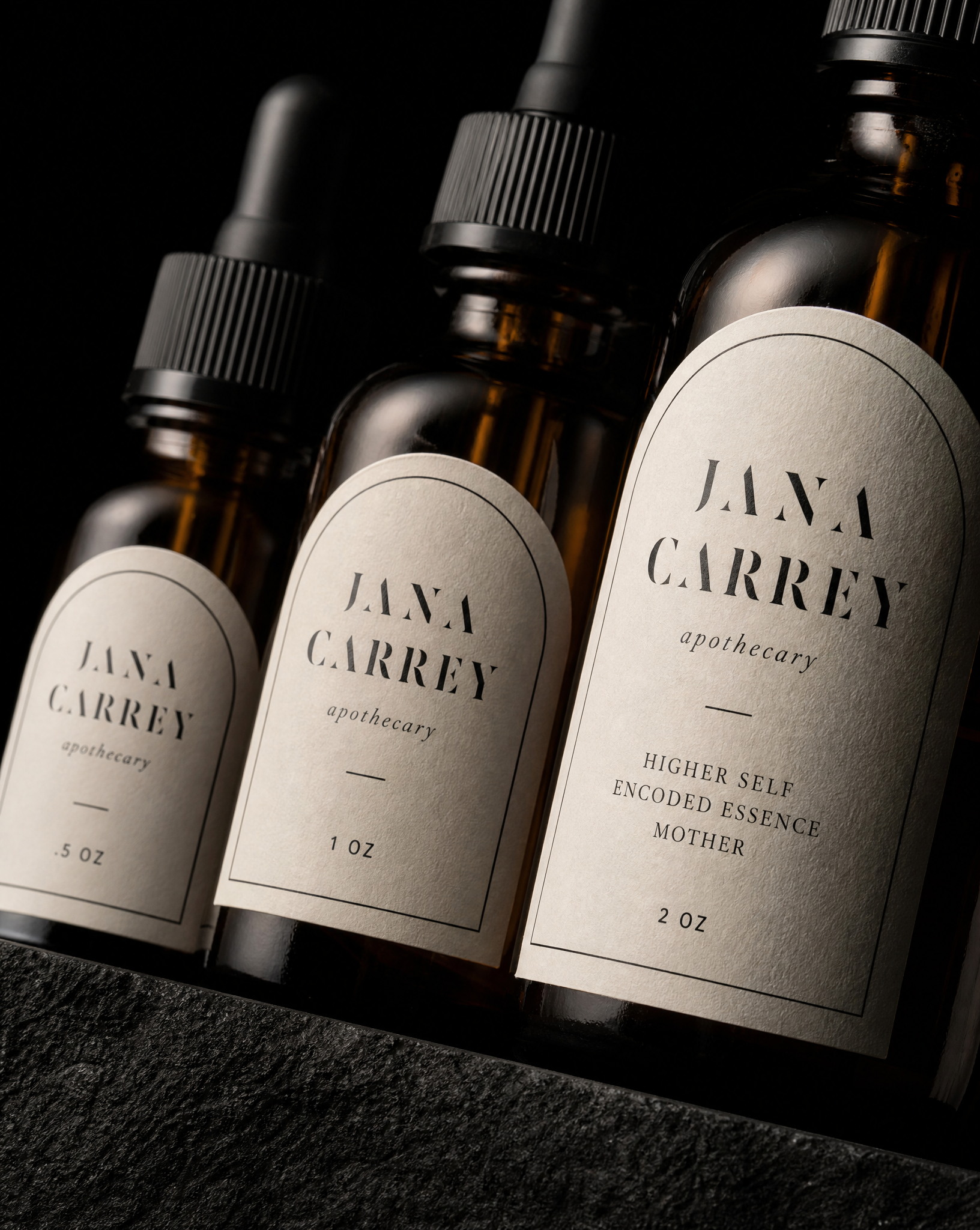 Close detail of the Jana Carrey Apothecary labels — 1.25 / 1.5 / 2 in tall, arch die cut, Cream uncoated label stock, 1-colour black, Kiss cut on roll.