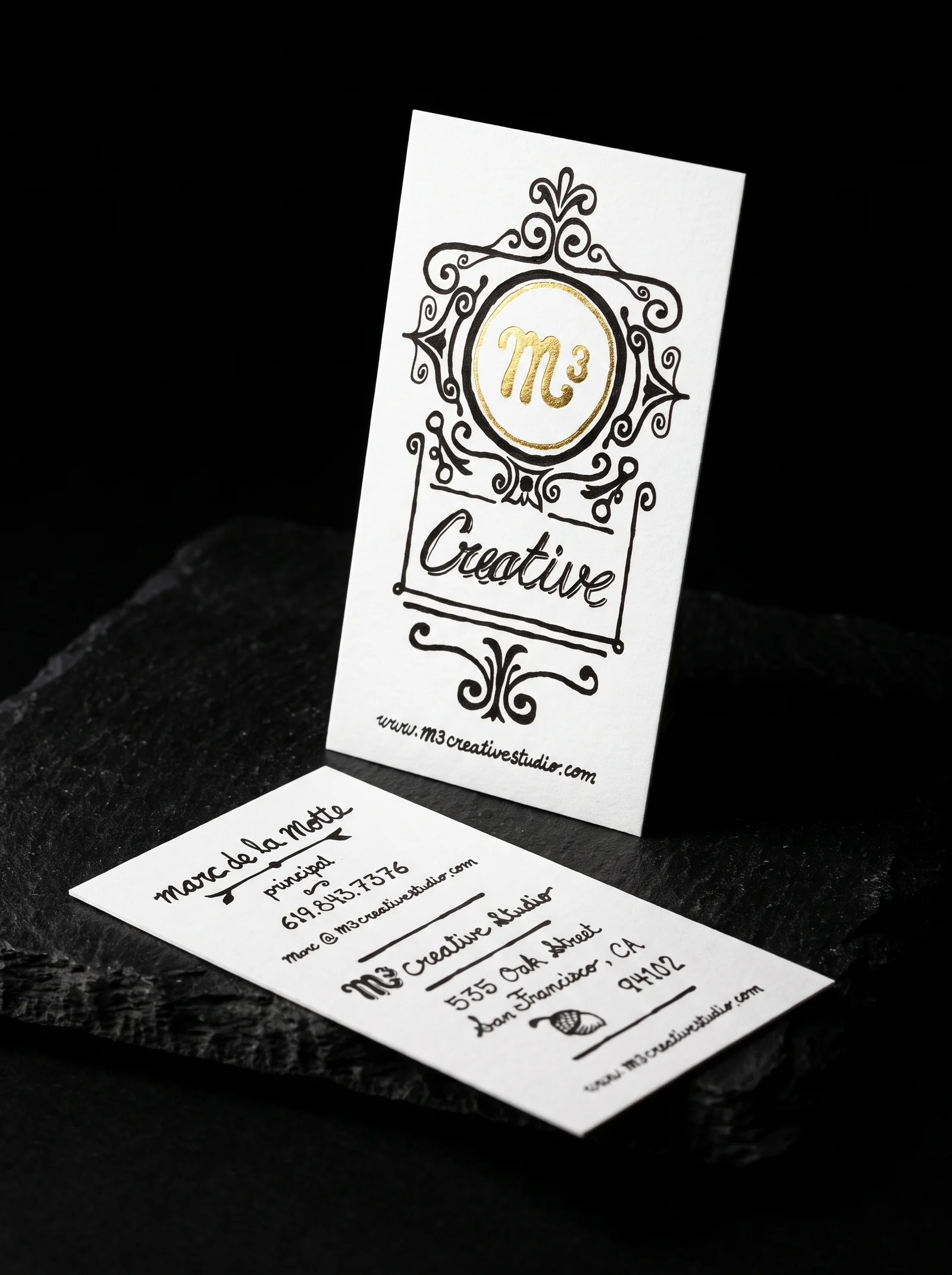 Business-cards for M3 Creative Studio with yellow gold foil stamping, 16-point silk matte stock, black ink, vertical format and hand-lettered.