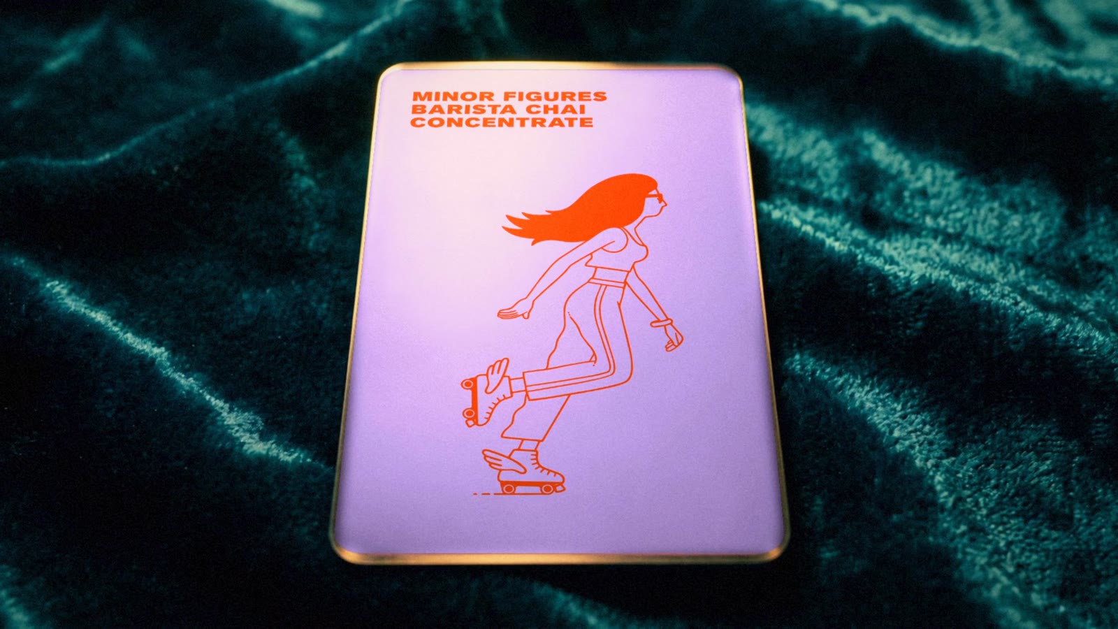The Minor Figures card, Look 1 The Carton: lilac face with the orange skater, on teal velvet