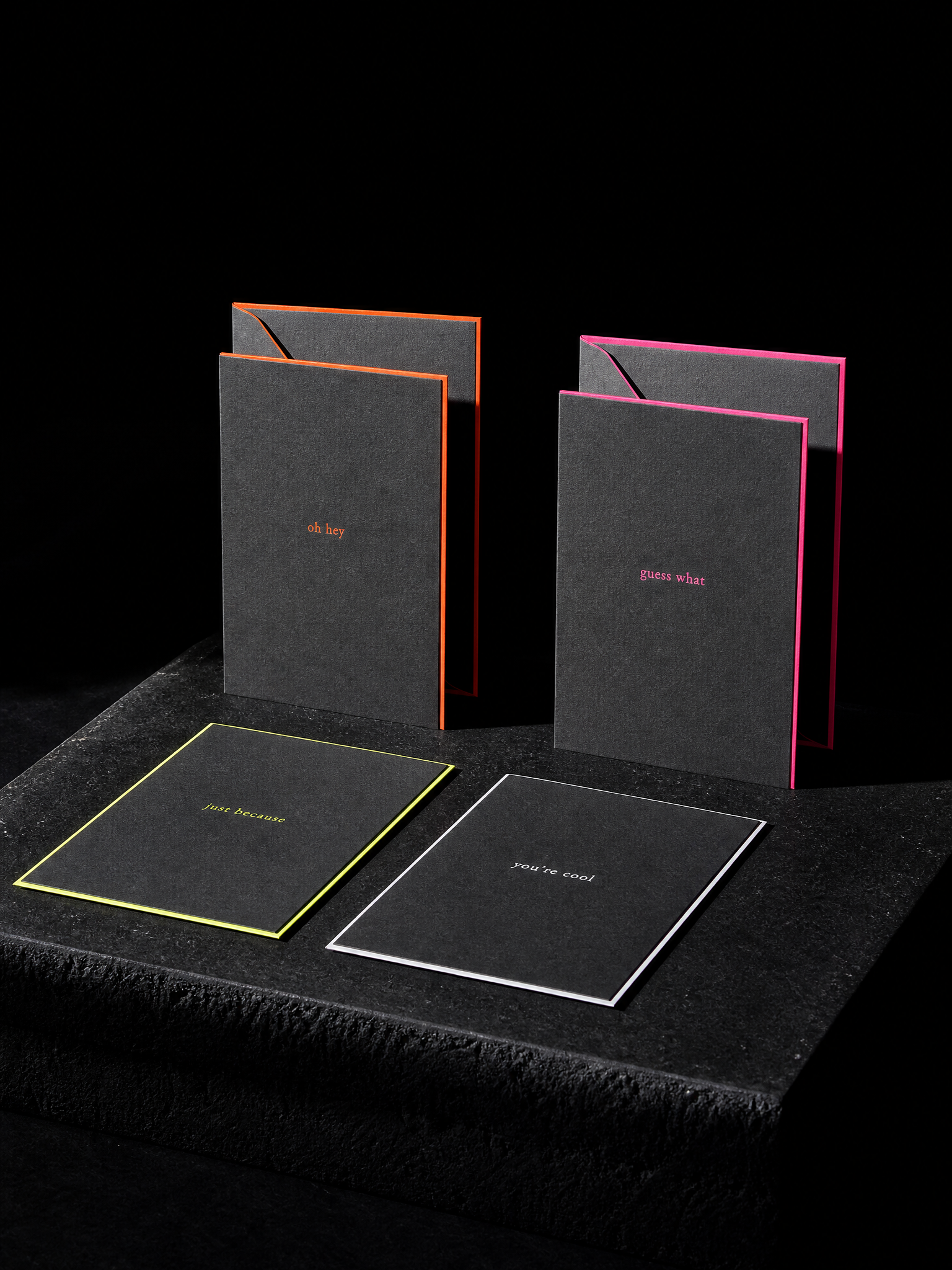 Notecards for Print Peppermint design exercise with four a6 notecards with matching envelopes, 32pt charcoal uncoated, the envelope flaps and card edges printed with a 2 mm border in fluorescent orange, fluorescent pink, chartreuse and white; a tiny lowercase phrase on each card: "oh hey", "guess what", "just because", "you're cool".