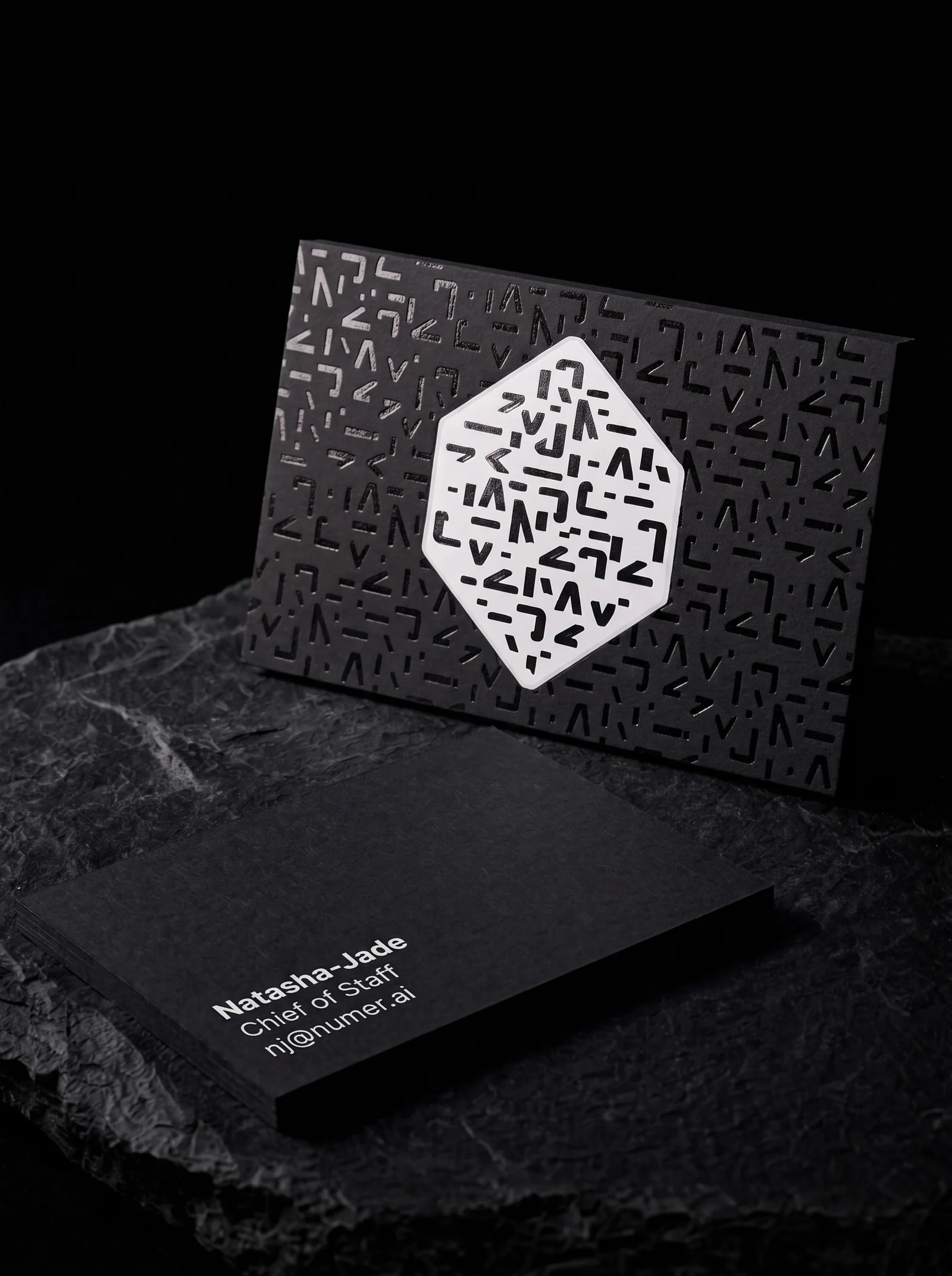 Business-cards for Numerai with white pigment and semi-gloss black , over white foil stamping, 2 × 3.5 in, square corners, 32pt uncoated black stock and two-sided.