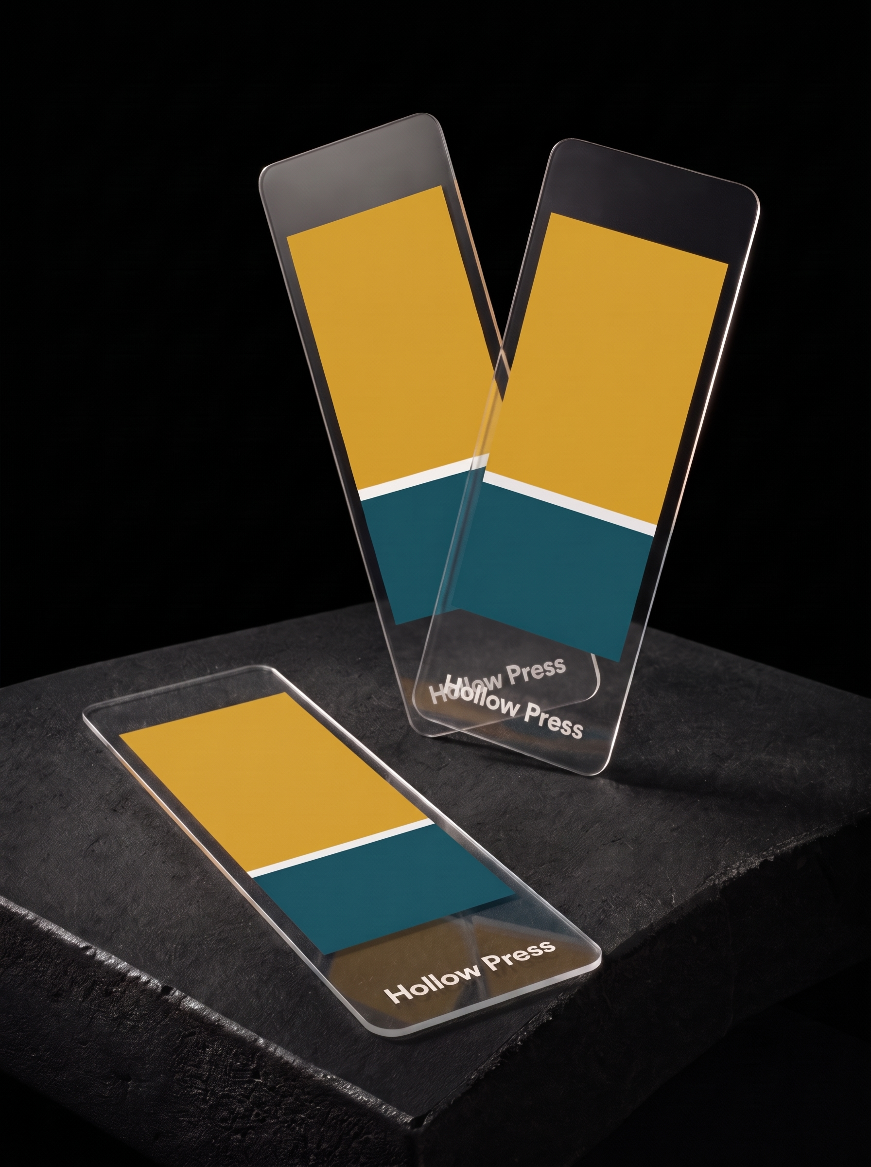 Three clear PVC bookmarks with mustard and teal Pantone blocks over opaque white underprint; the slate shows through the unprinted plastic.