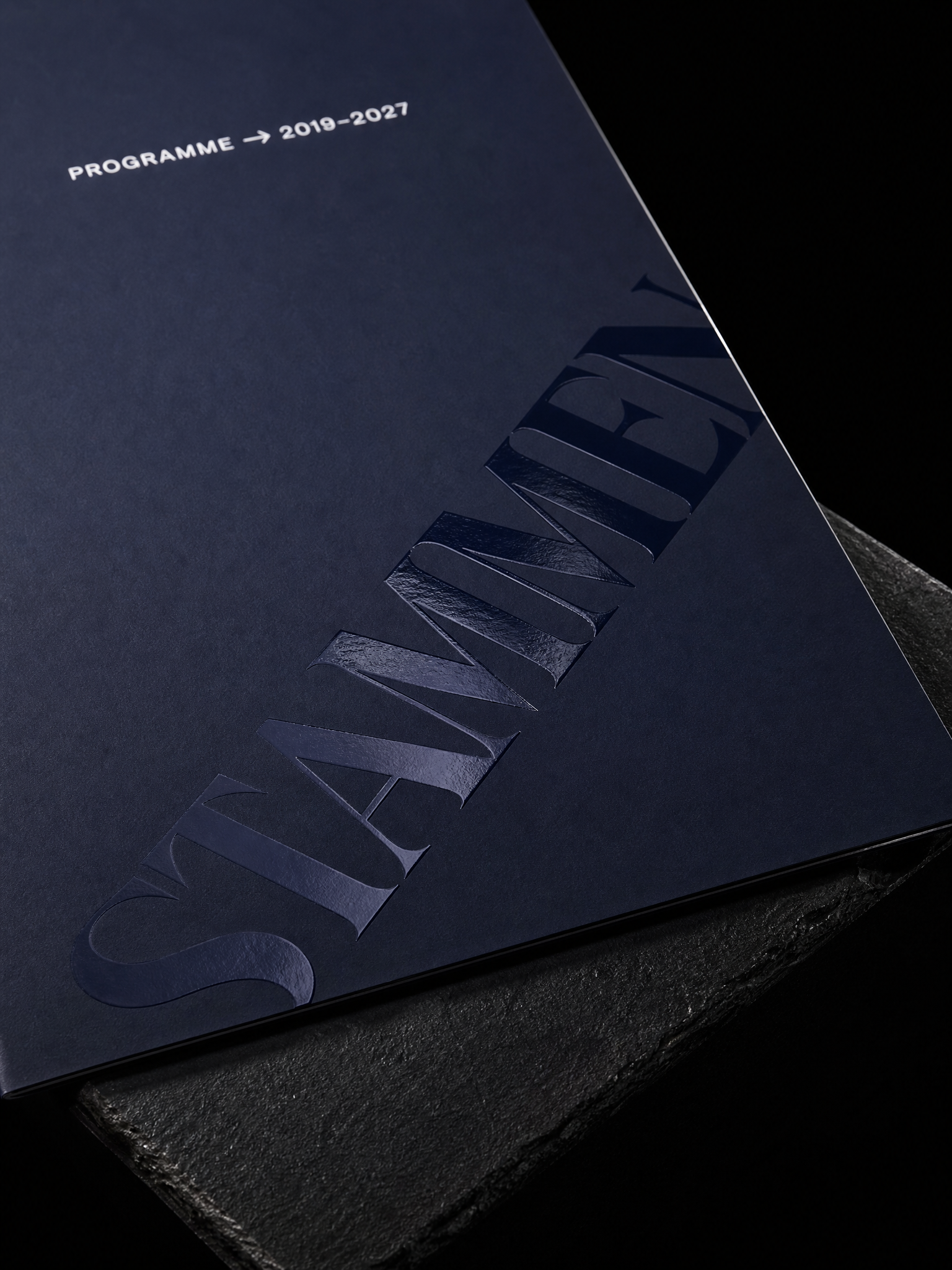 Navy soft-touch folder raised spot uv diagonal retro serif macro — custom folders by Print Peppermint, specialty print with raised spot uv, spot uv, soft touch laminate