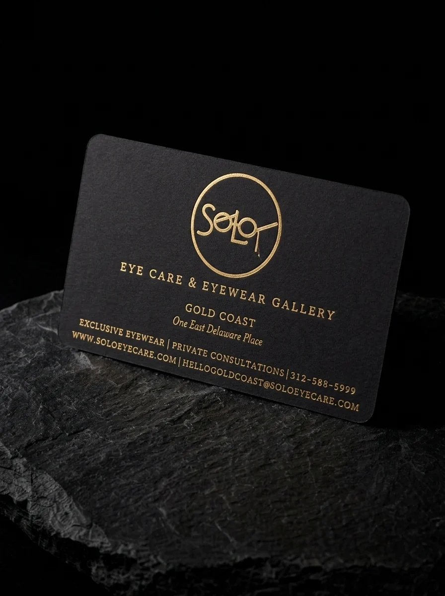 Business-cards for SoLo Eye Care & Eyewear Gallery with yellow gold foil stamping, black uncoated stock, rounded corners and single-sided.