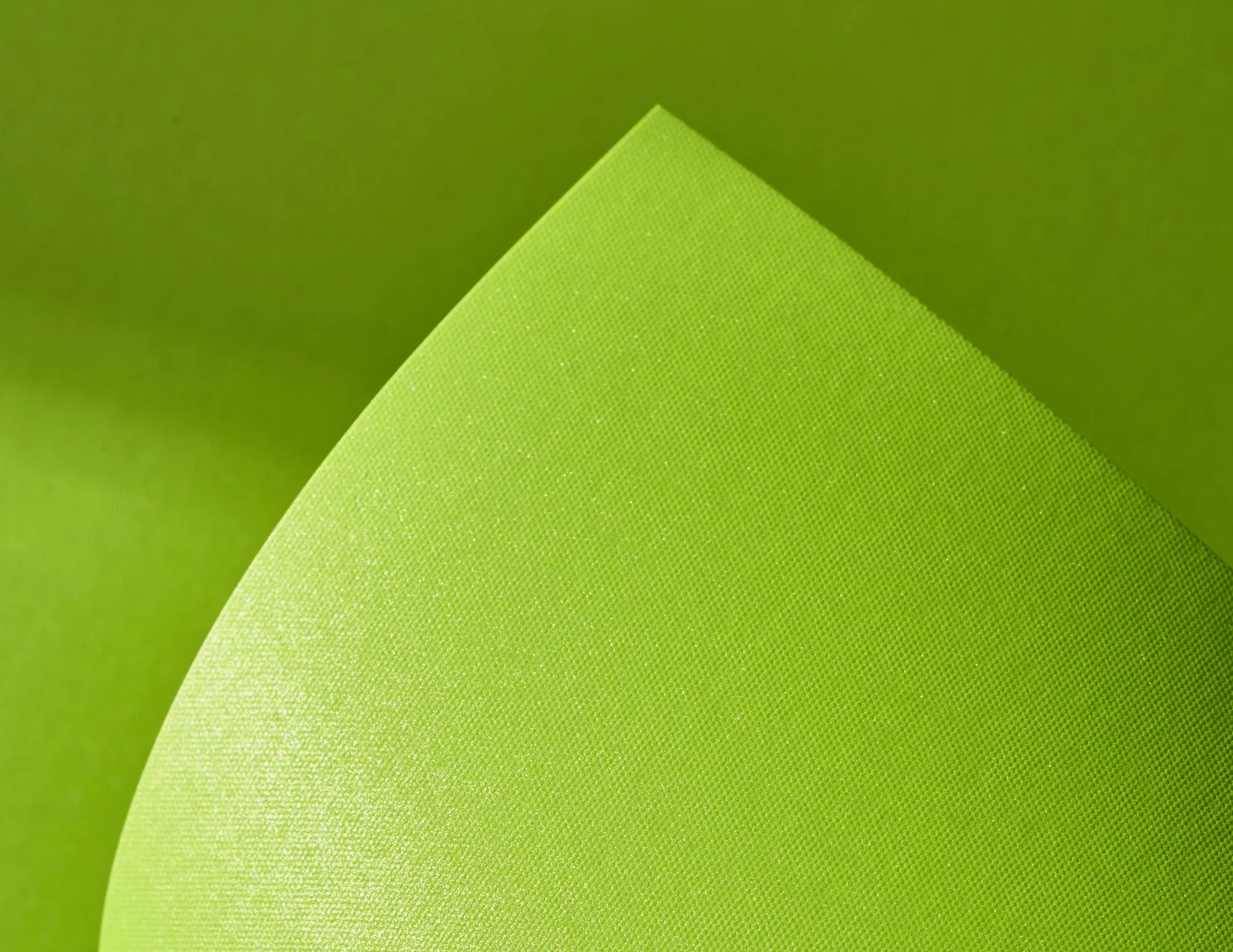 A curled sheet of Gmund Action Nuclear Acid catching the light