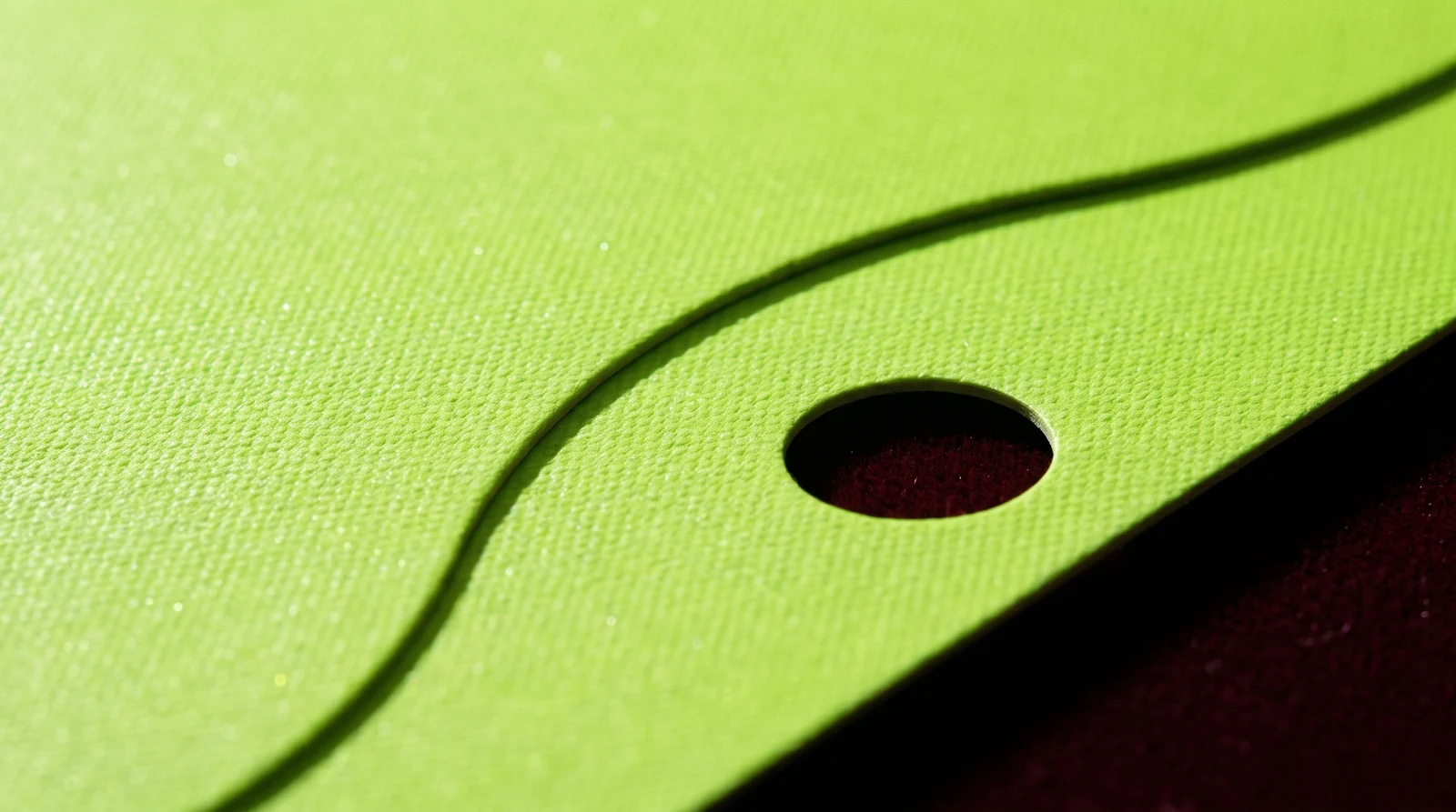 Macro of the paper's canvas texture with a die-cut curve and a punched hole