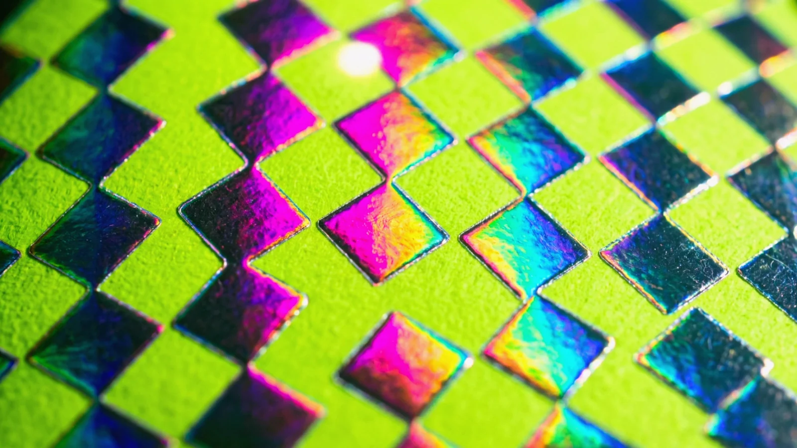 Macro of Silver Prism Squares holographic foil on neon green paper