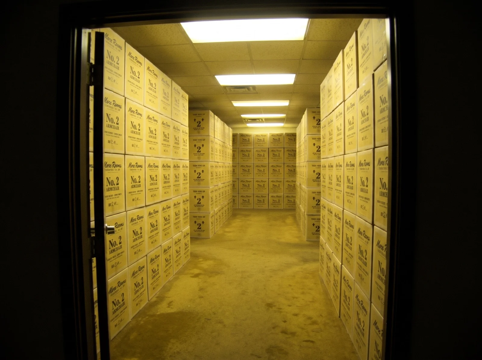 Camcorder frame of a stockroom doorway opening onto endless corridors of stacked yellow boxes