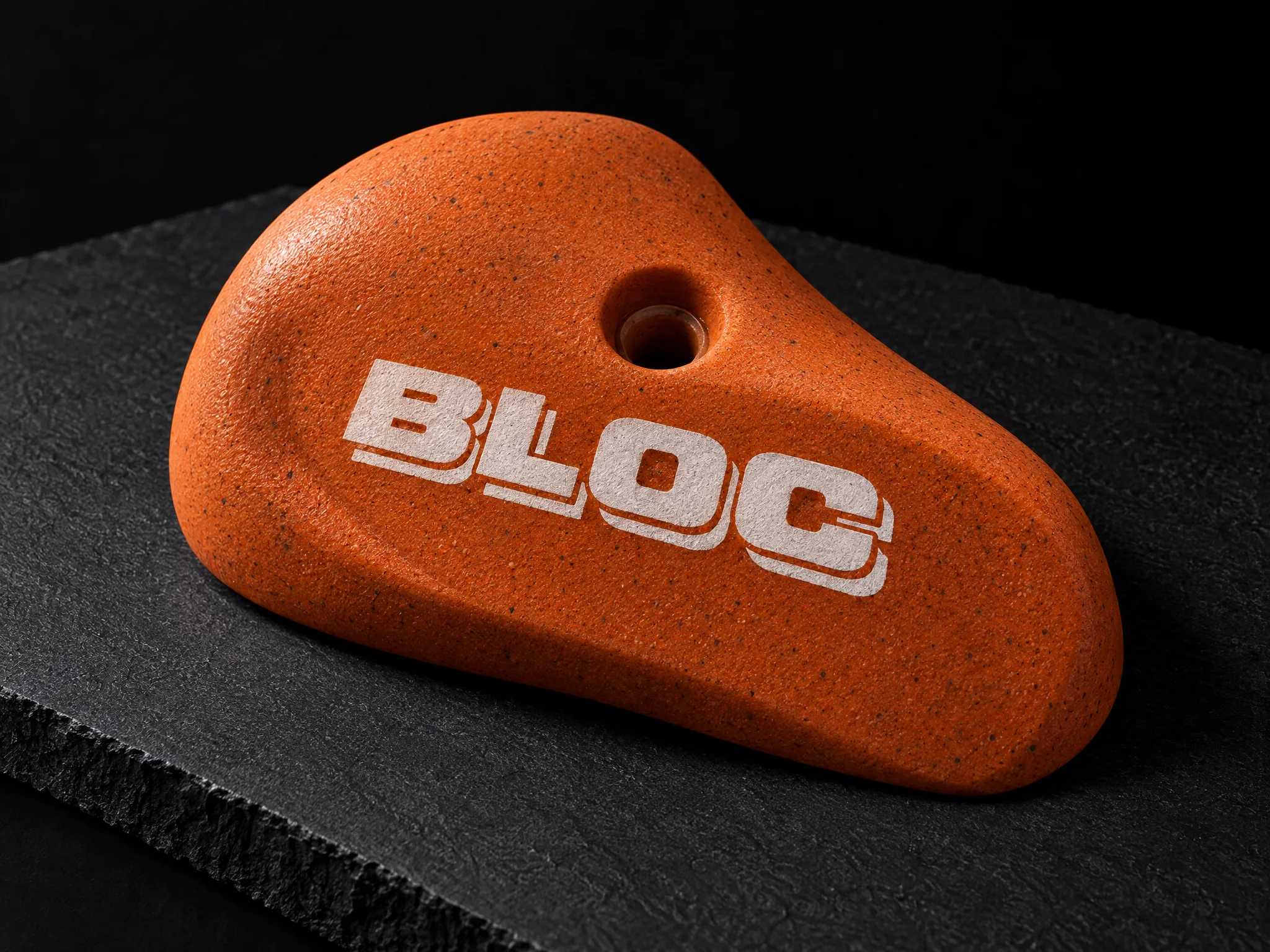 BLOC climbing gym identity, designed by Print Peppermint, printed in raised white ink on an orange climbing hold