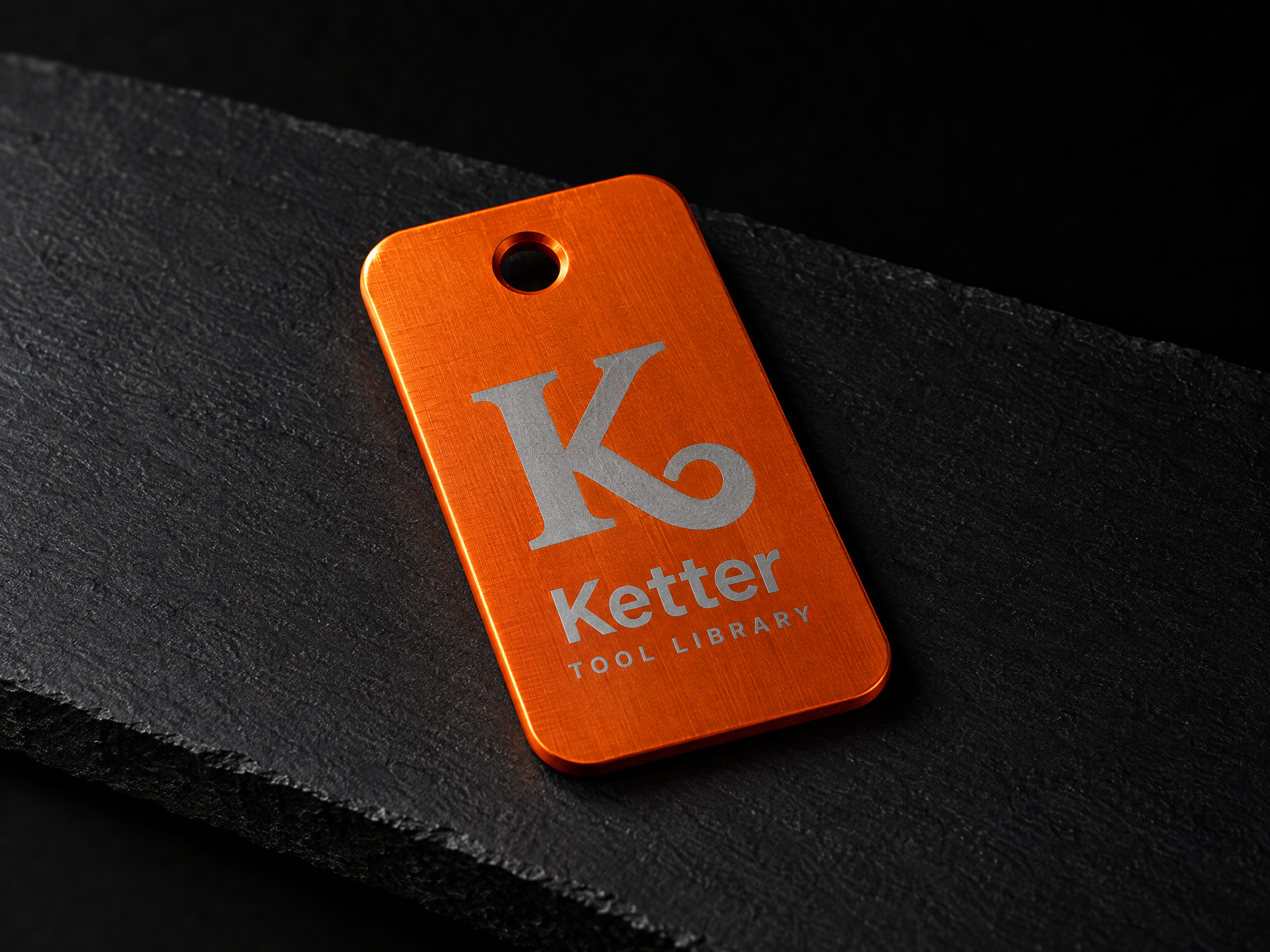 Ketter Tool Library identity, designed by Print Peppermint, printed in pale blue on an orange metal tool tag
