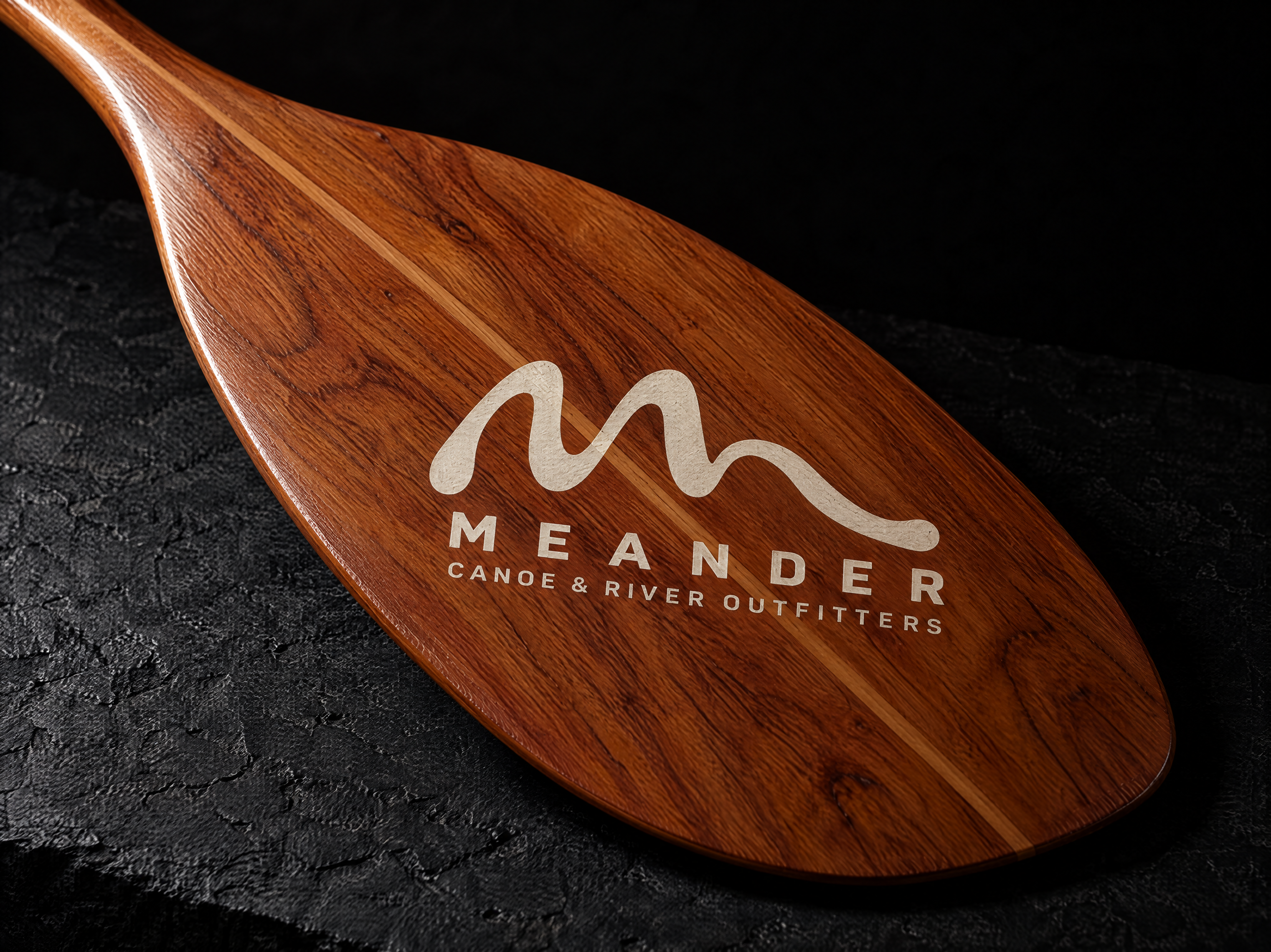 Meander logo and brand identity for a canoe and river-trip outfitter, designed by Print Peppermint, shown in application