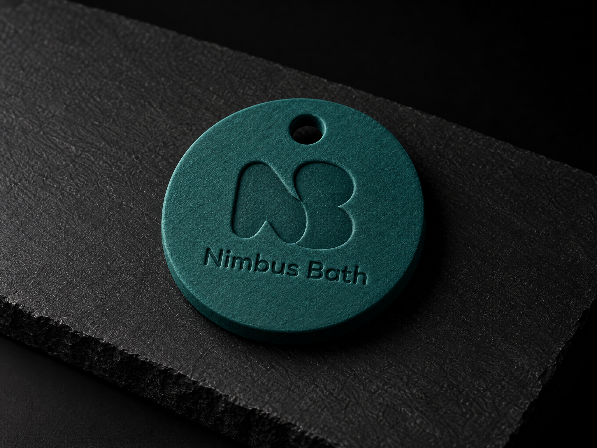 Nimbus Bath public bathhouse identity, designed by Print Peppermint, debossed on a teal bath token