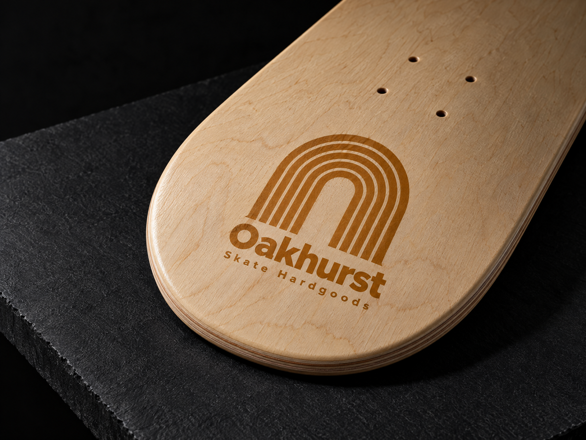 Oakhurst skate hardgoods identity, designed by Print Peppermint, printed in orange on a natural maple skateboard deck