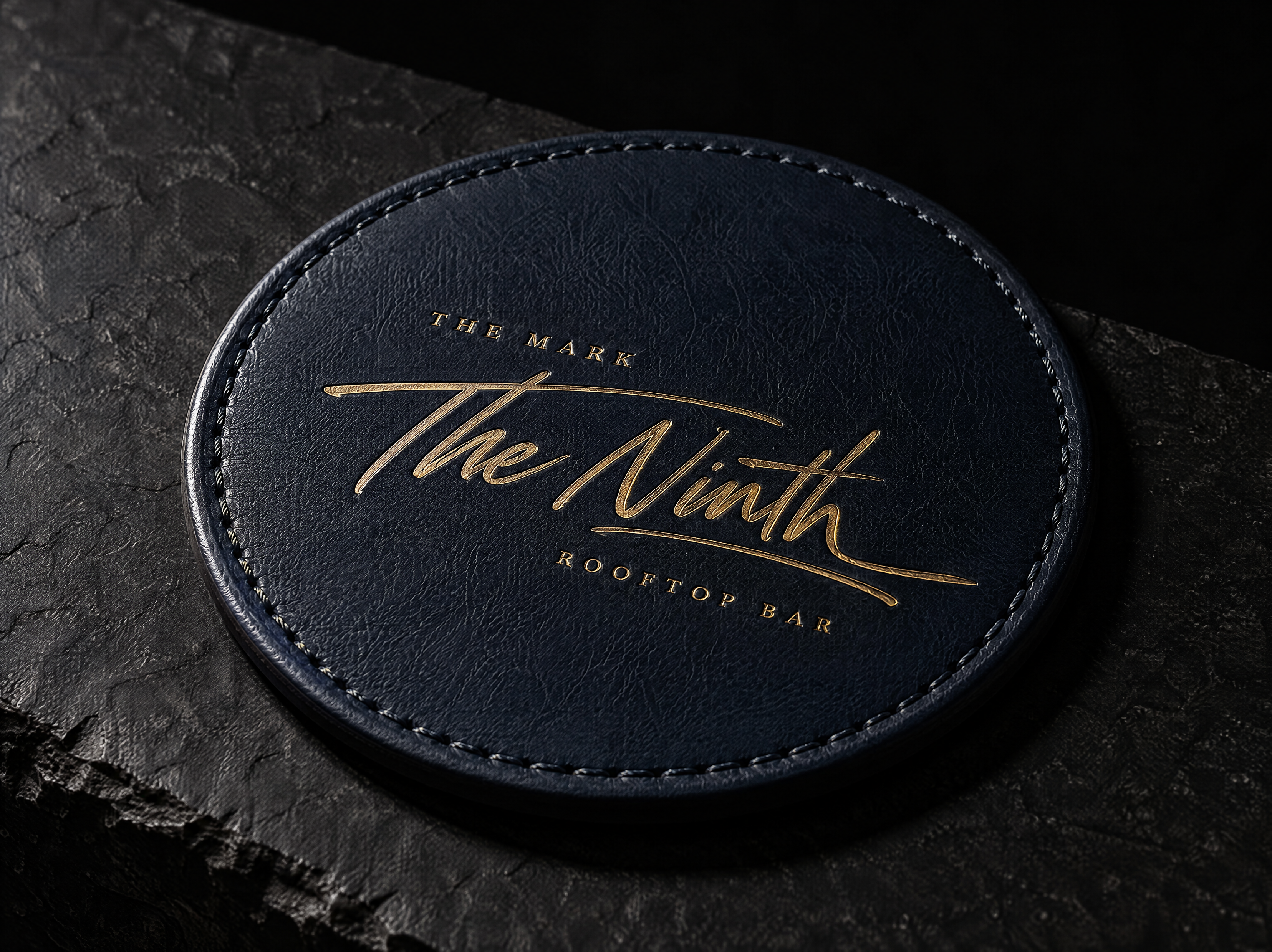 The Ninth logo and brand identity for a rooftop cocktail bar on the ninth floor, designed by Print Peppermint, shown as a gold hot-foil stamp pressed into the leather