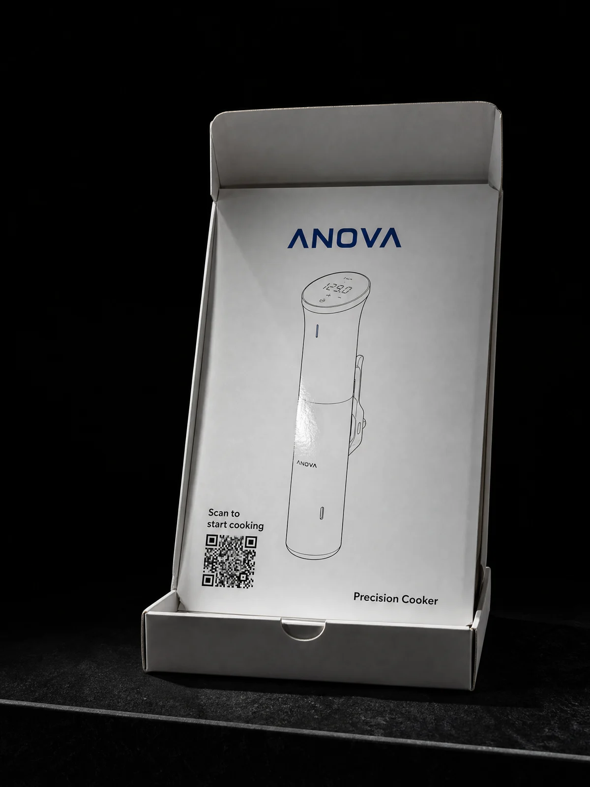 Anova Culinary product box opened to reveal a fitted printed insert card on a black studio plinth