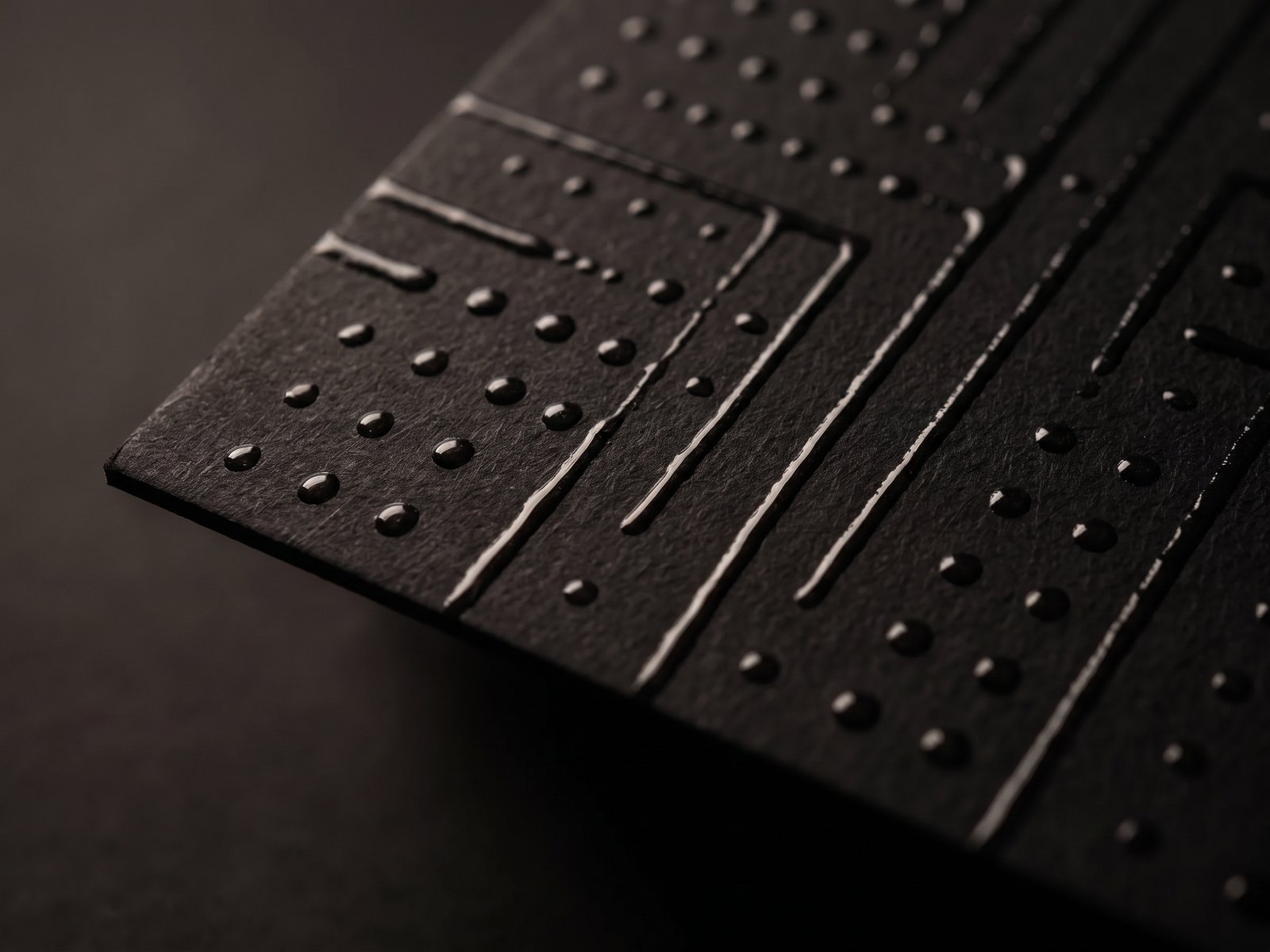 Tactile raised clear spot UV on matte black laminated stock