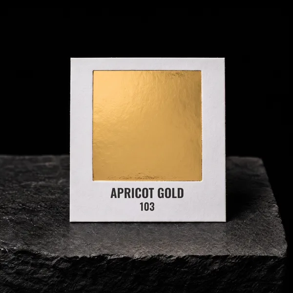 Apricot Gold 103 foil chip photographed on slate