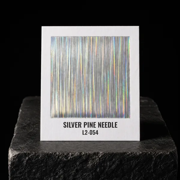 Silver Pine Needle L2-054 foil chip photographed on slate