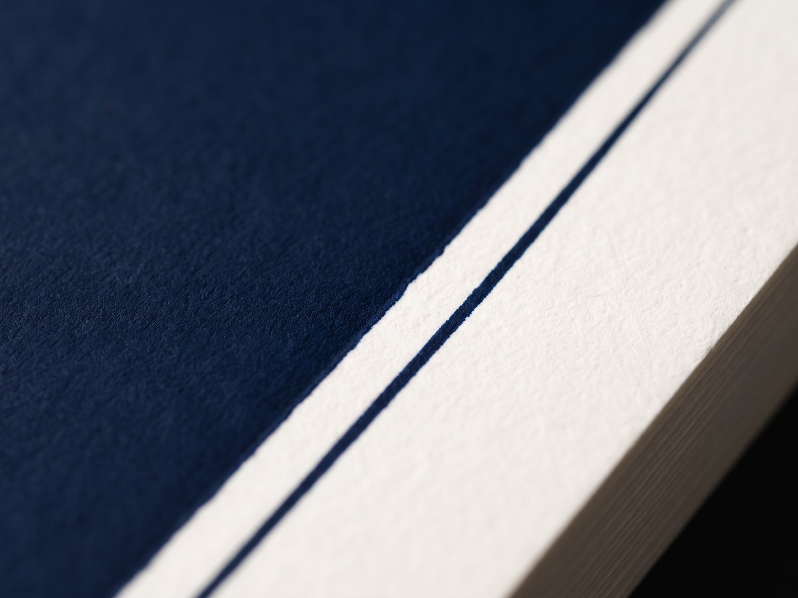 Navy spot ink letterpress impression in textured white paper