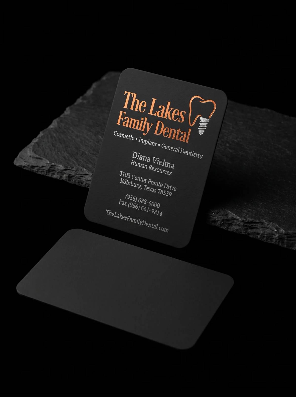 Black business card stamped in two foils, from the Lakes Family Dental case study