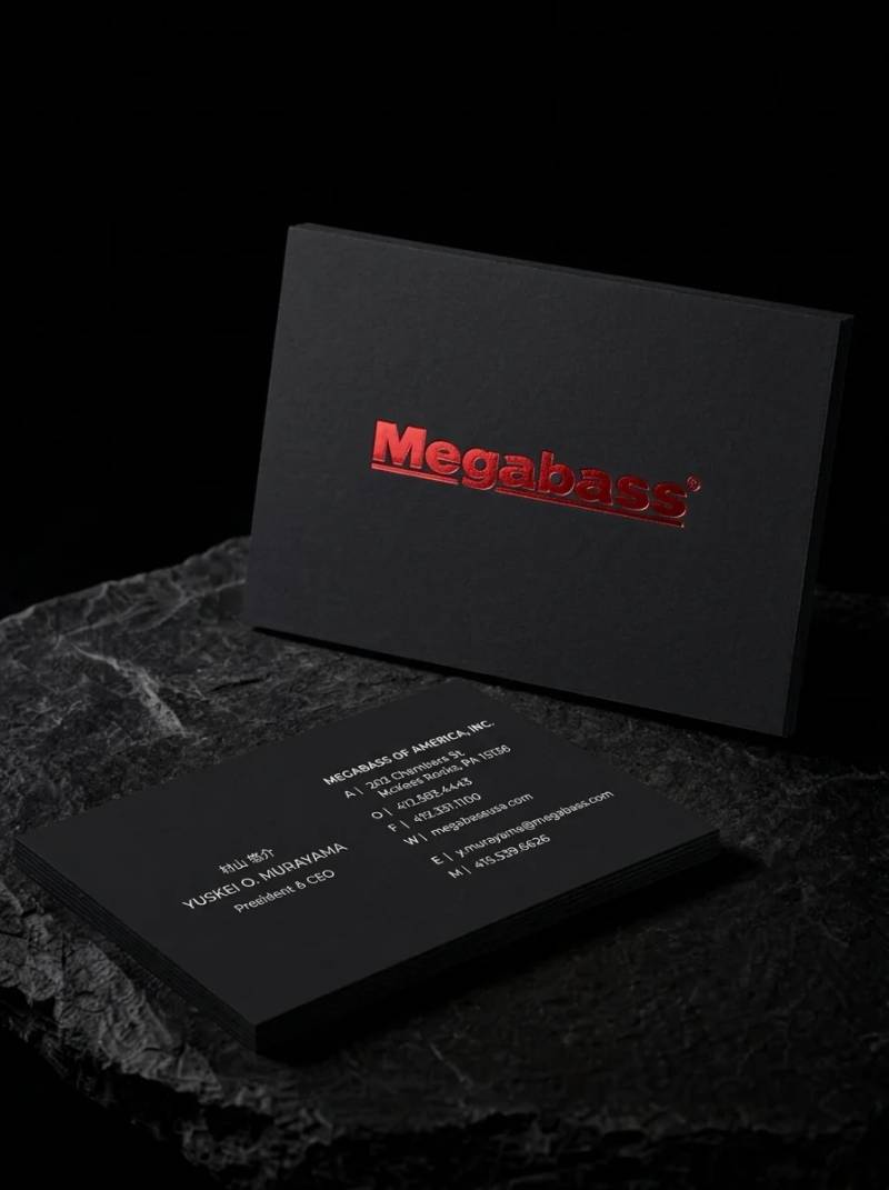 Megabass black business card: Red foil wordmark on black · bilingual reverse