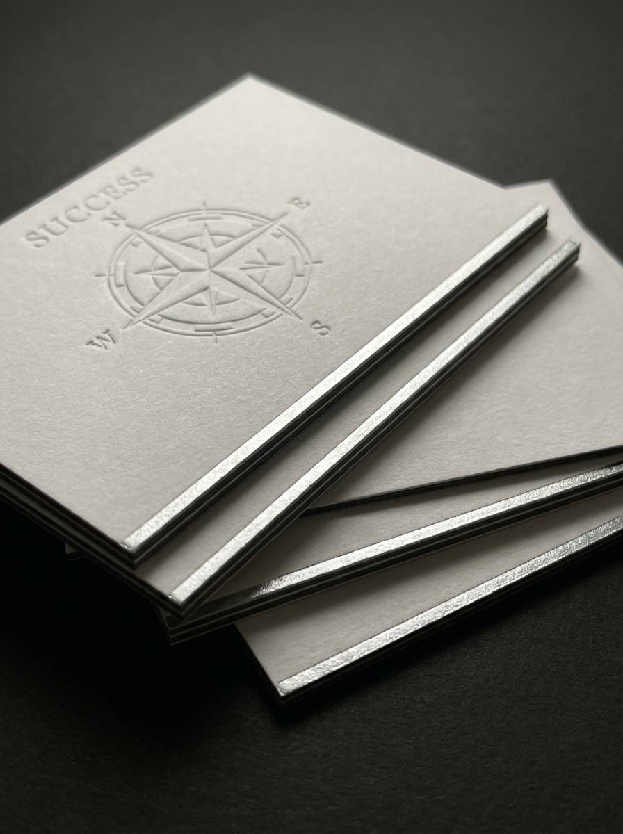 The Tactile Shift concept: 48pt duplex cotton/charcoal · deep emboss · hot foil edge